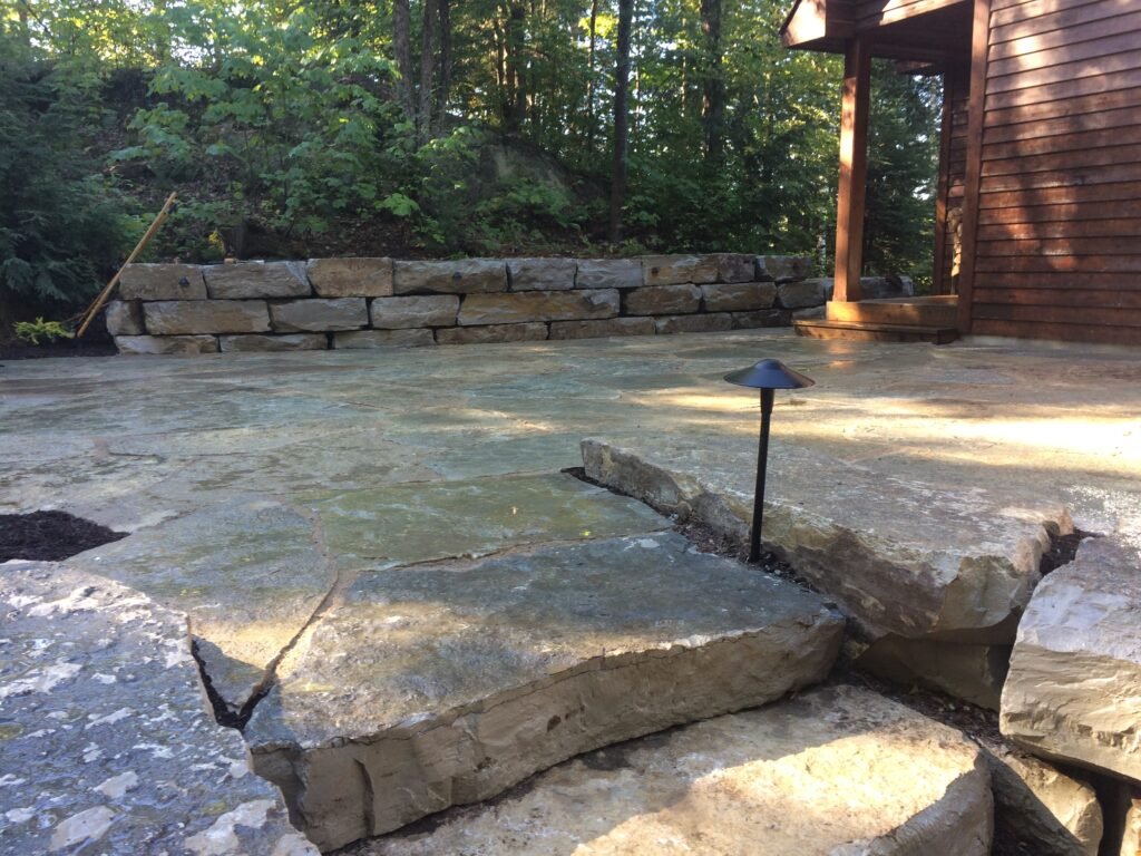 Natural flagstone patio with an armour stone retaining wall