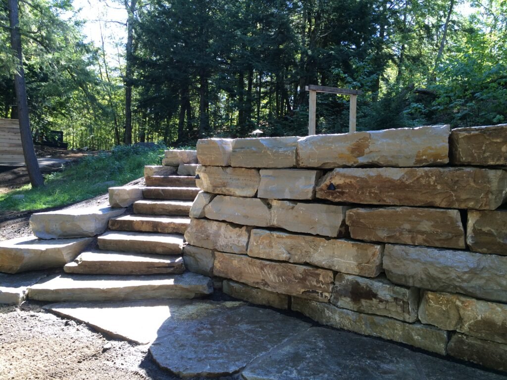 Armour stone steps and retaining wall under the trees