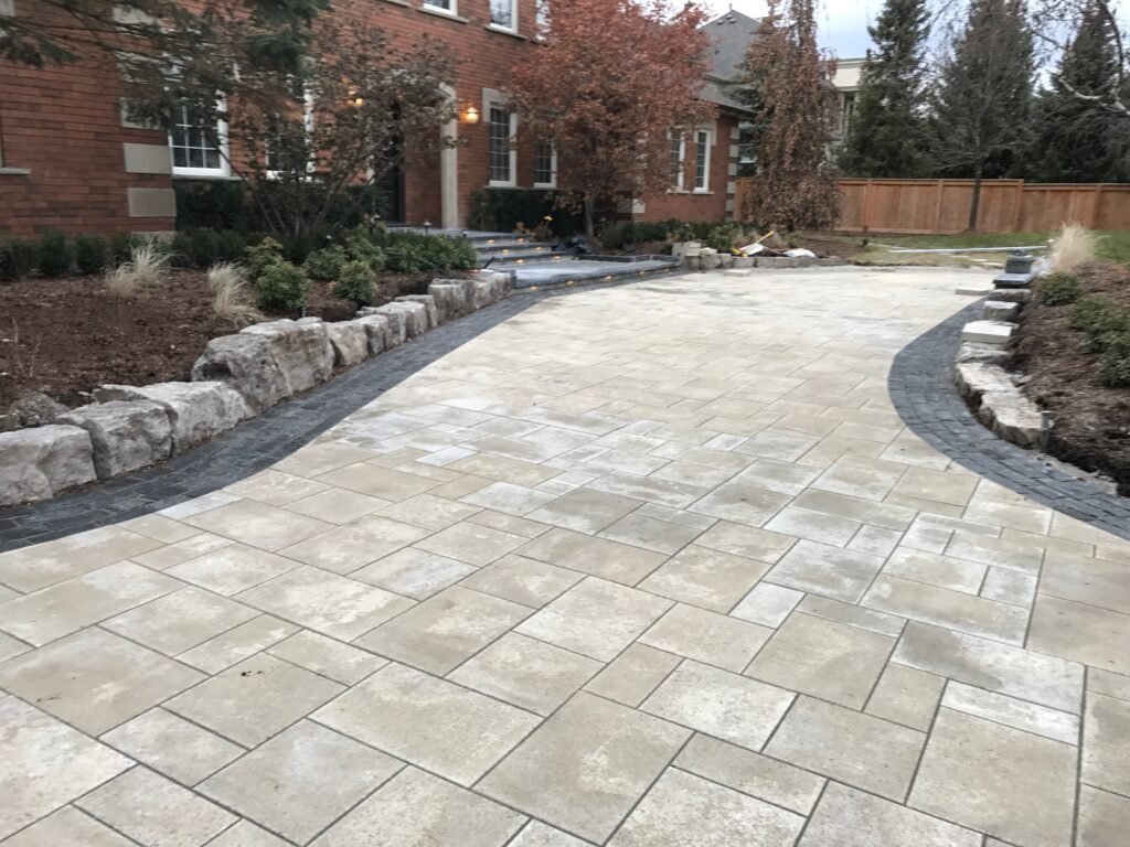Large paver patio edged with armour stone and planting