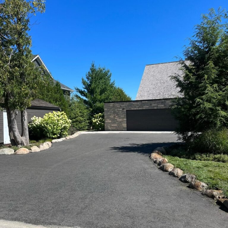 Granite boulder edging along a new driveway. Thor Construction job photo.