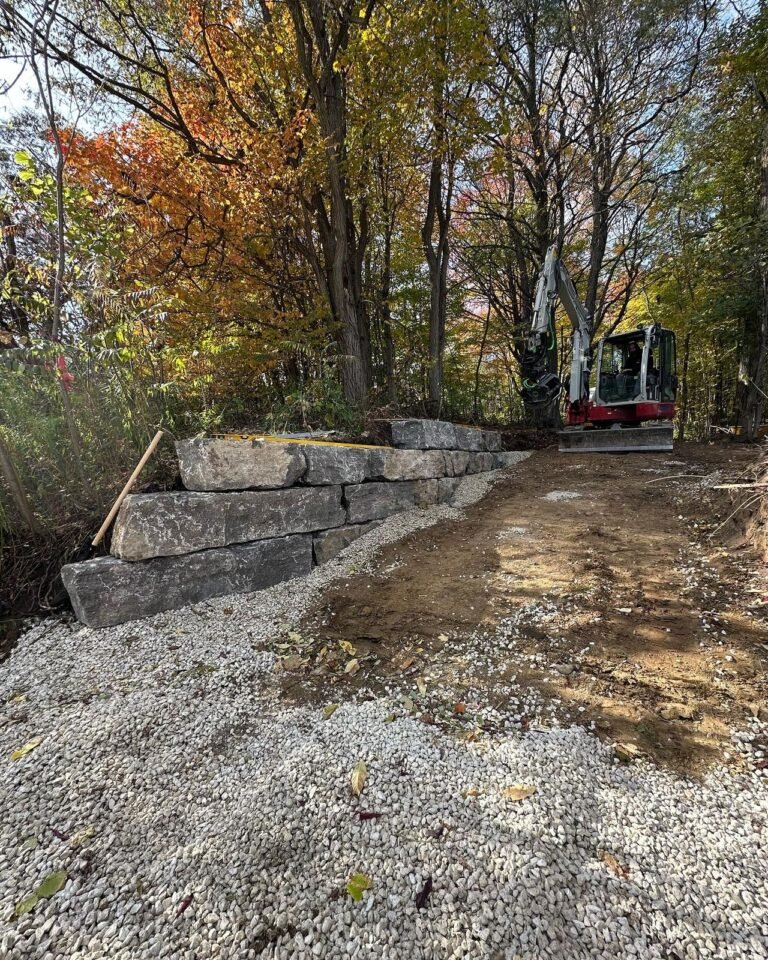 Armour stone walls along a new driveway. Thor Construction job photo.