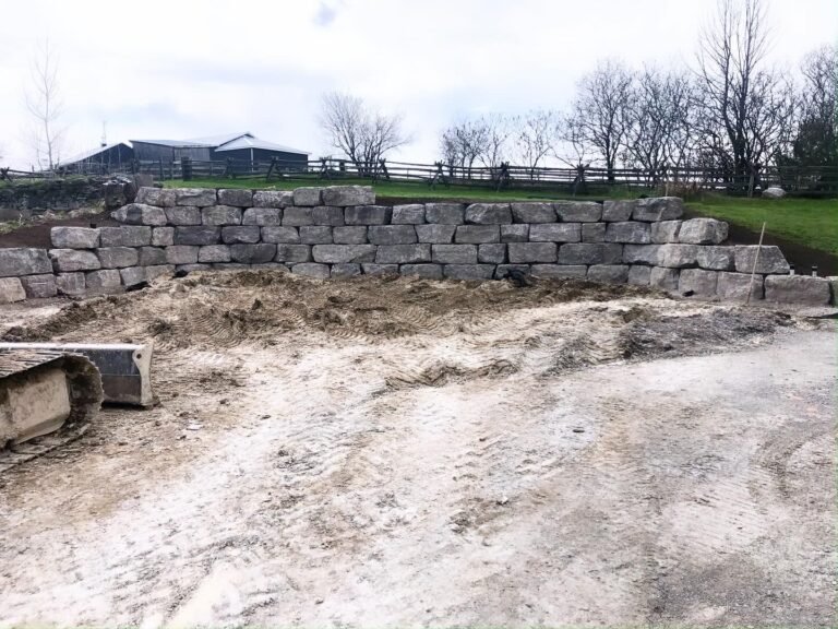 Armour stone retaining wall build, Kawartha Lakes. Thor Construction job photo.