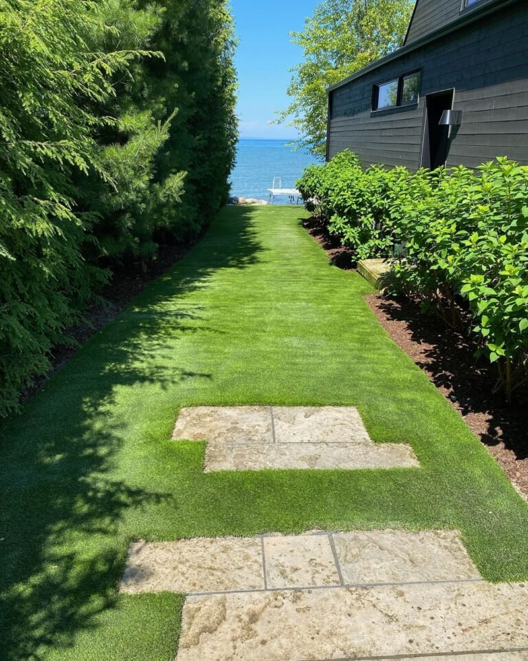 Finished landscape: sod, boulders and a stone patio. Thor Construction job photo.