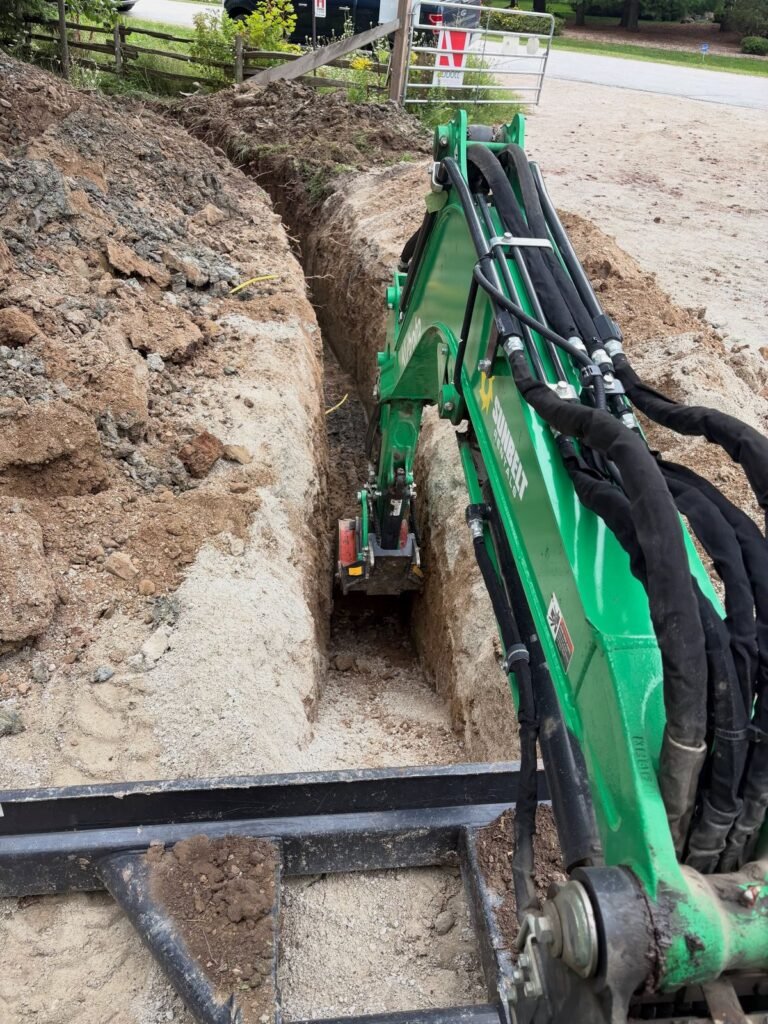 Utility trench with the compact excavator. Thor Construction job photo.