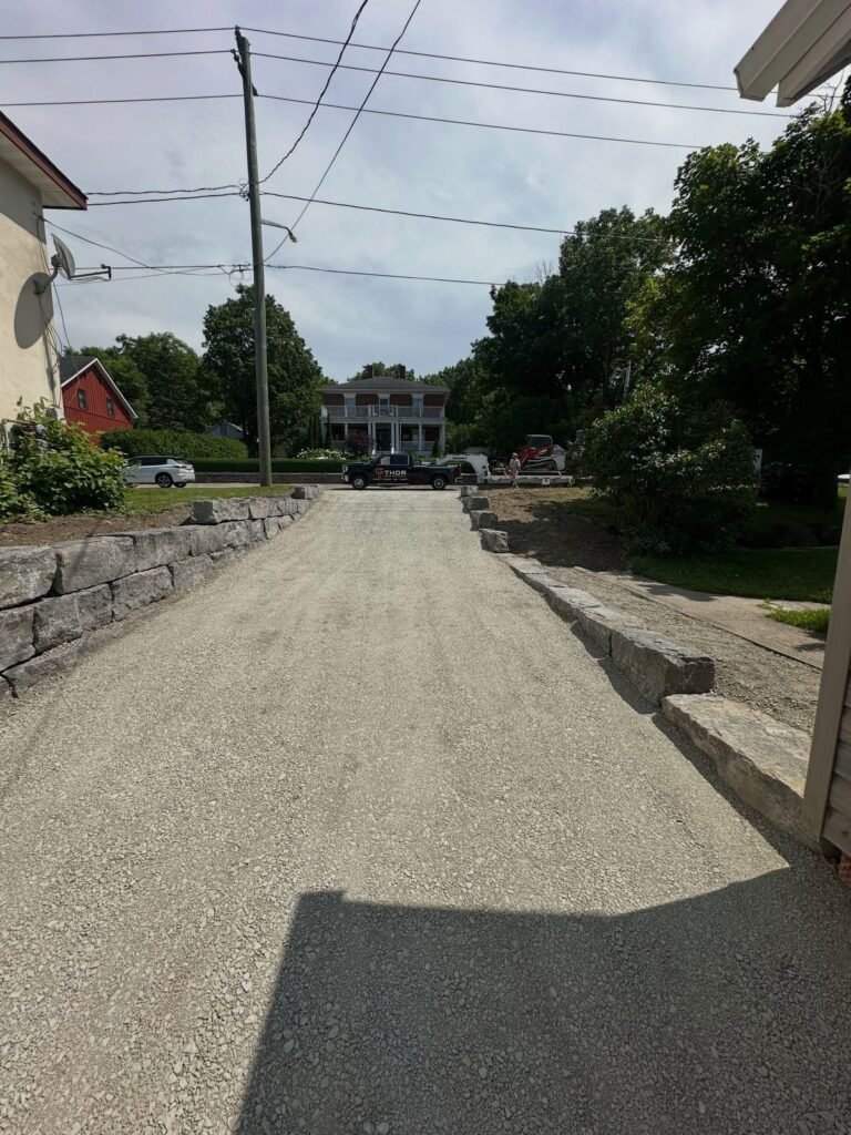 New driveway with armour stone retaining walls. Thor Construction job photo.