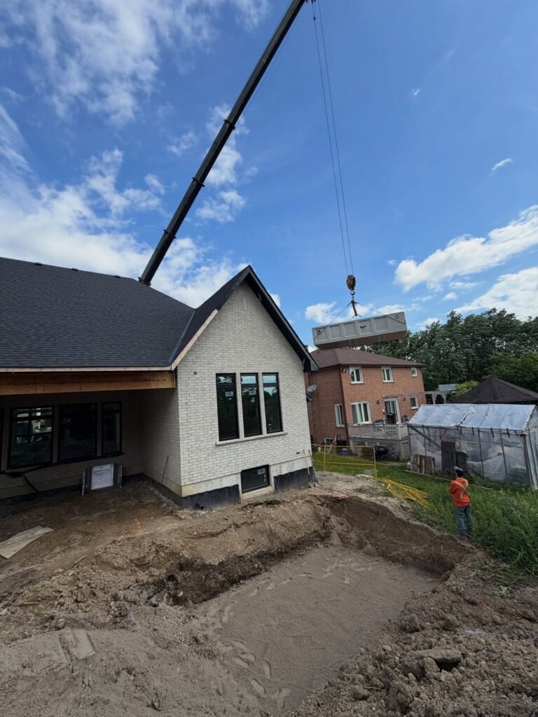 Craning a two-piece septic tank over a new build, Pickering. Thor Construction job photo.
